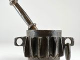 une vieille casserole en fonte munie d'une poignée en métal et d'une poignée en bois