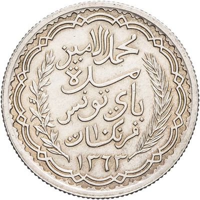 a close up of a silver coin with arabic writing on it
