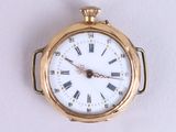 a gold pocket watch with roman numerals on the face