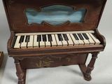 un piano miniature posé à côté d'un livre