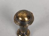 a close up of a brass knob on a white surface