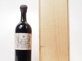 une vieille bouteille de vin posée à côté d'une caisse en bois sur un fond blanc