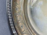 a silver plate with a red stripe on it on a table