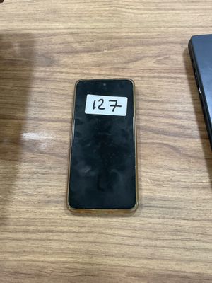 a cell phone sitting on a table next to a laptop