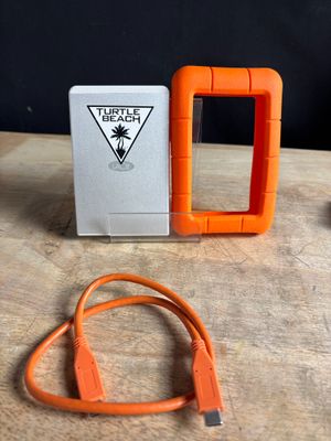 an orange hard drive and a charger sitting on a table