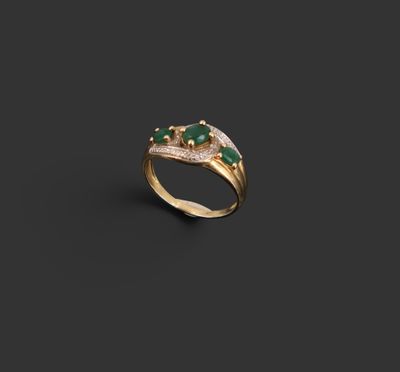 une bague en or sertie d'une émeraude et de diamants