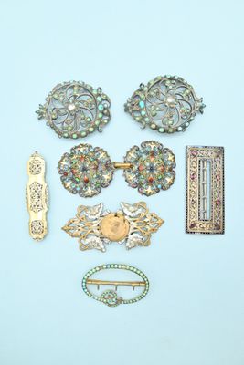 a lot of brooches and hair clips on a blue surface