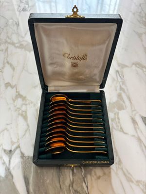 a box with six spoons in it sitting on a marble table