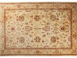 un tapis beige avec une bordure rouge et un motif floral