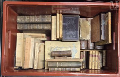 une boîte rouge remplie de vieux livres posée sur une table