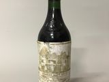 une vieille bouteille de vin posée sur une table blanche