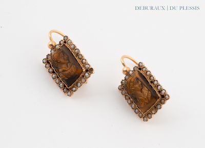 pair of earrings with a picture of a woman and a man on them