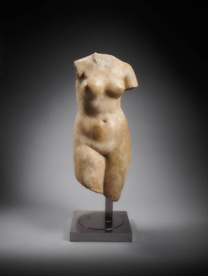 une statue en marbre représentant un torse féminin, posée sur un socle