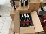 Des cartons de vin sont empilés sur des palettes dans un magasin