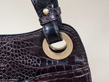 an image of a brown purse with a gold ring on the handle