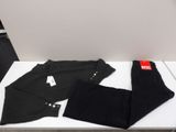 two pairs of black pants sitting on top of a white table