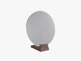 an image of a round mirror on a wooden stand
