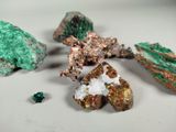 several different colored rocks and crystals on a white surface