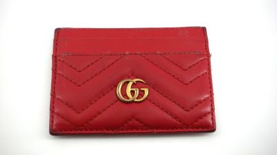 un gros plan d'un portefeuille rouge orné d'un logo GG doré