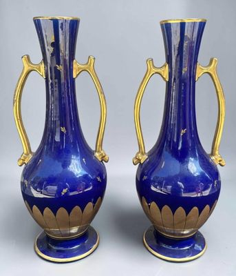 pair of blue and gold vases with handles on each of them