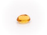 a yellow sapphire stone on a white background