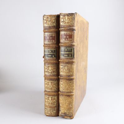 deux vieux livres posés l'un sur l'autre sur une surface blanche