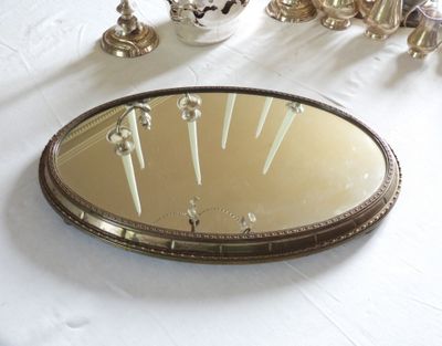 un miroir posé sur une table, dans lequel se reflètent des bougies