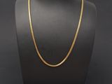 a gold chain necklace on a mannequin display