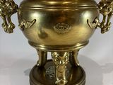a large brass urn on a stand with two handles