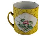une tasse jaune et blanche ornée d'une fleur