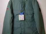 La veste est verte et porte une étiquette.