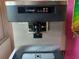 a water dispenser that is next to a pink refrigerator