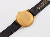 a close up of a watch on a black strap on a white surface