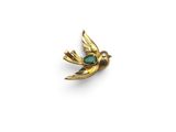an image of a gold bird with a green stone in its beak