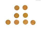Plusieurs pièces d'or sont disposées en triangle sur un fond blanc
