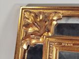 a mirror with a gold frame on the wall
