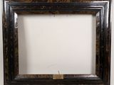 an old picture frame with a tag on it sitting on a wall