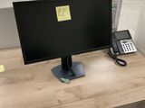 un bureau sur lequel se trouvent un téléphone et un écran d'ordinateur
