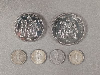 four different types of coins are shown on a white surface