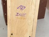 a small wooden box with a purple sticker on it