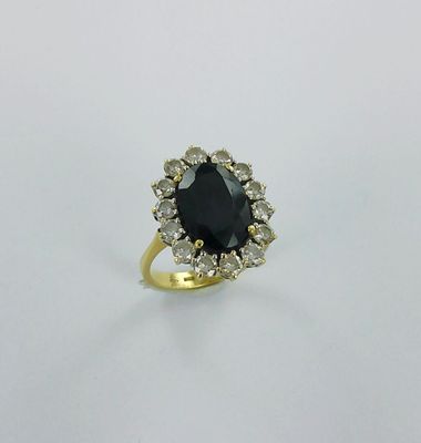 une bague en or sertie d'une pierre noire entourée de diamants blancs