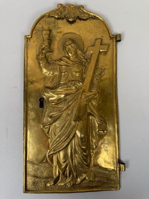 une plaque plaquée or représentant une femme tenant une croix