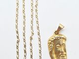un gros plan d'un collier en or et d'un pendentif en or sur un fond blanc