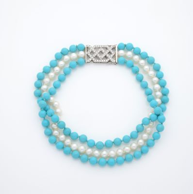 un bracelet en perles blanches et bleues avec un fermoir en argent