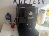 a coffee maker sitting on a table next to a cup of coffee