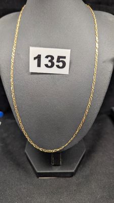 un gros plan d'un collier porté par un mannequin, avec une étiquette de prix
