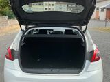 the back of a white car with its trunk open in a parking lot