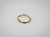 gros plan d'une bague en or sur une surface blanche