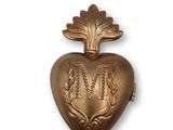 brass heart shaped locke with initials and leaves on a white background