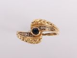gros plan d'une bague en or avec une pierre en saphir